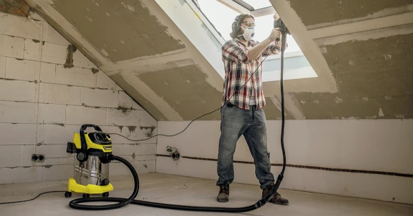 Un homme utilise l'aspirateur Kärcher WD6 premium avec une ponceuse